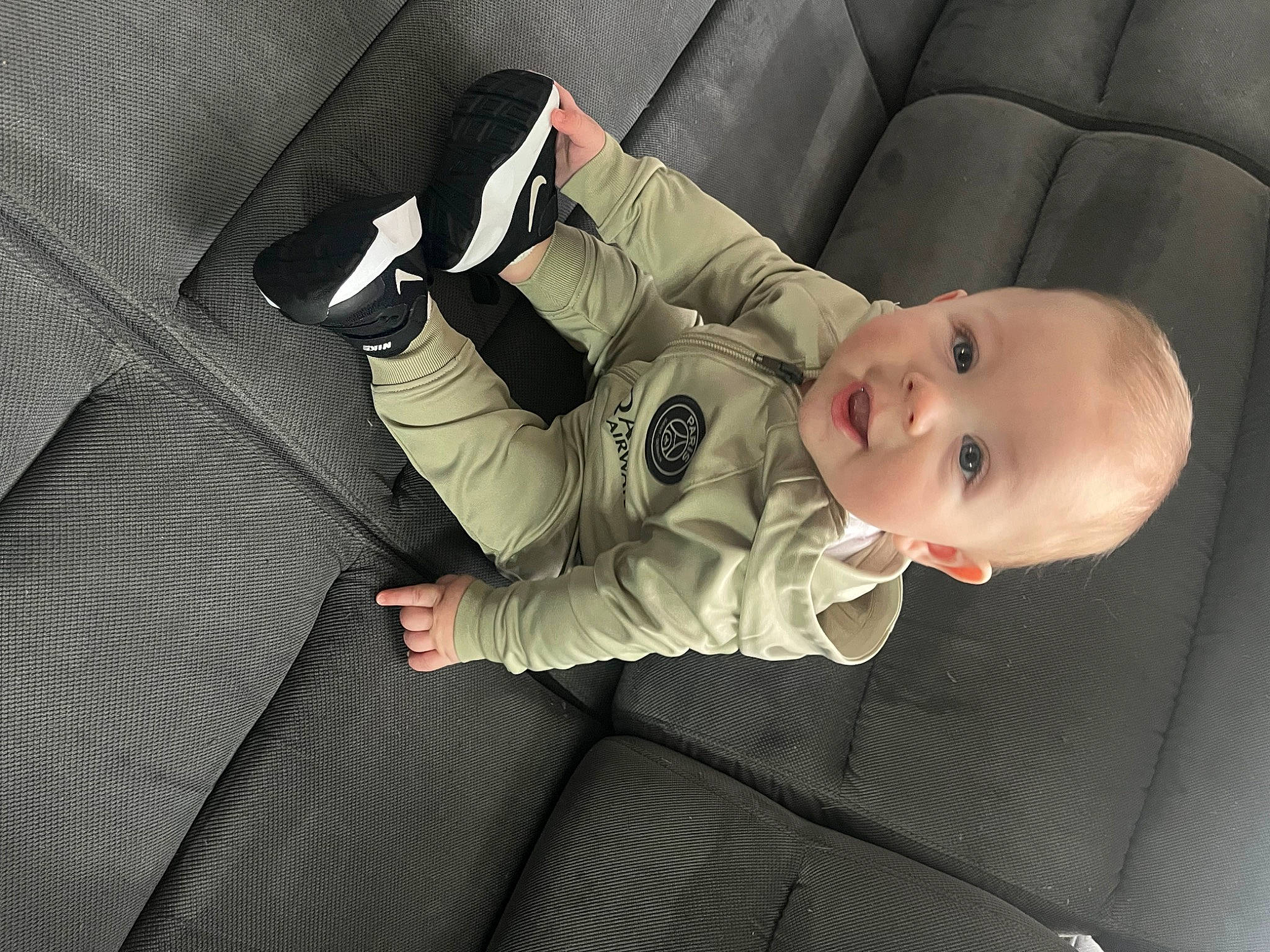 Juliano participe au concours pour gagner de l'argent avec cette photo : arm, baby, baby_products, baby_toddler_clothing, carmine, cheek, child, comfort, finger, grey, linens, monochrome, pattern, person, sitting, sleeve, smile, toddler, wood