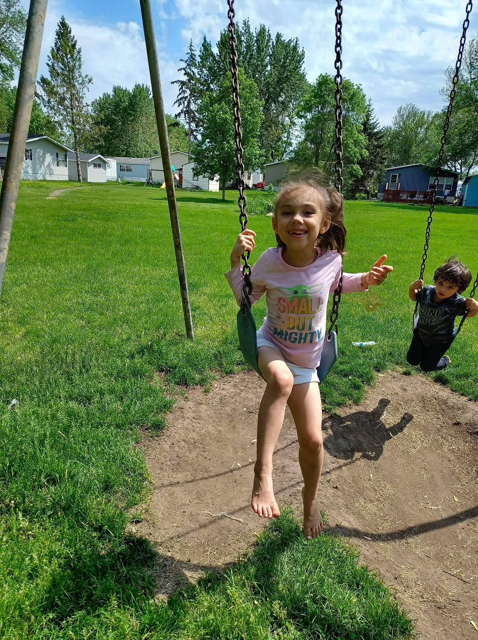 Naomi is registered to the contest to win money with this photo: city, cloud, fun, grass, grass_family, happy, joy, landscape, lawn, leisure, outdoor_play_equipment, people_in_nature, person, plant, pole, recreation, sky, smile, soil, swing