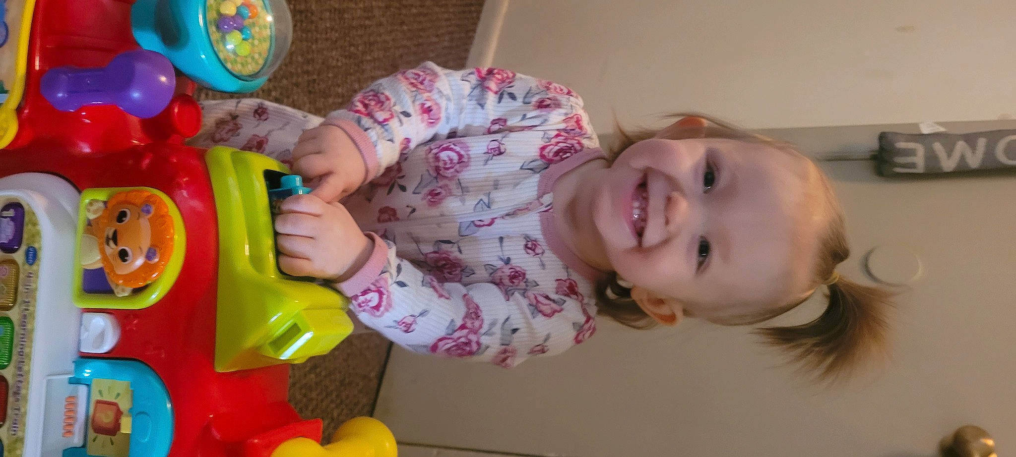 Ariel is registered to the contest to win money with this photo: arm, baby, baby_playing_with_toys, baby_toddler_clothing, baby_toys, child, face, fun, happy, head, joy, organ, person, pink, plastic, play, room, skin, smile, toddler