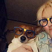 Lil Boy joined the competition — help win amazing prizes! dog, person, indoor, glasses, selfie, pet, animal, face, hand, holding, brown_and_white_dog, casual, cute, portrait, cozy, human, animal_companion, playful, relaxed, dim_lighting