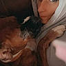 Kona is registered to the contest to win money with this photo: woman, dog, bulldog, pet, cuddle, portrait, headscarf, face, eyes, wrinkles, sleepy, indoors, sofa, blanket, close_up, selfie, brown, white, companionship, relaxed