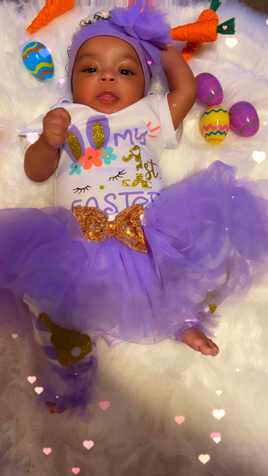 Amirez joined the competition — help win amazing prizes! baby, child, tutu, headband, purple, easter_eggs, plush_carrots, fluffy_surface, hearts_overlay, onesie, bow, smiling, cute, holiday, celebration, infant, lying_down, decorations, festive, soft_texture