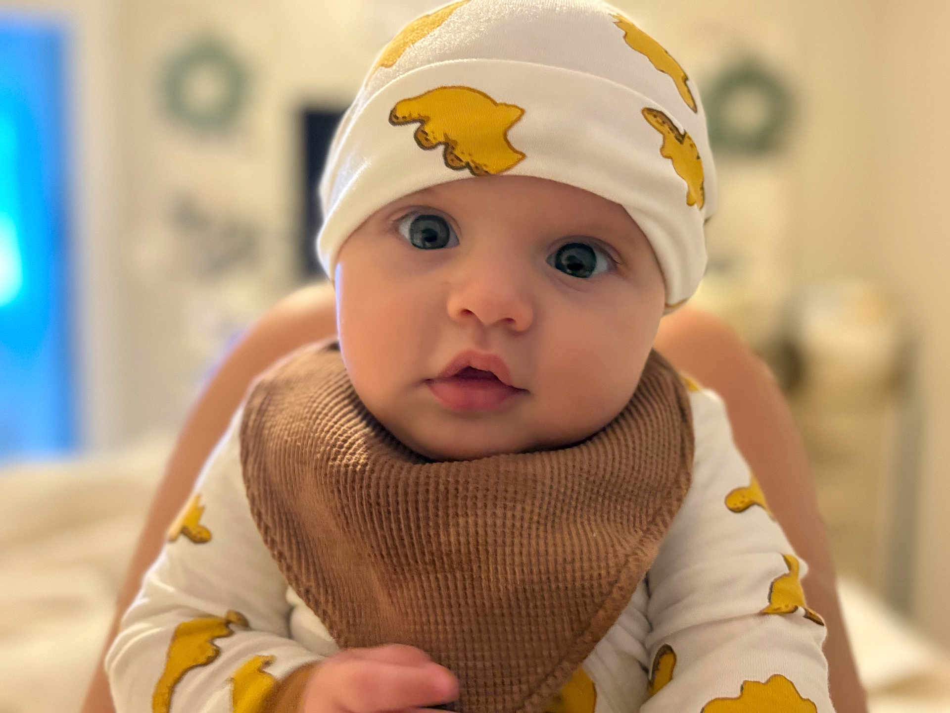 Cash joined the competition — help win amazing prizes! baby, infant, face, blue_eyes, hat, bib, clothing, cute, indoor, portrait, child, person, skin, expression, looking, young, yellow, white, focus, soft_light