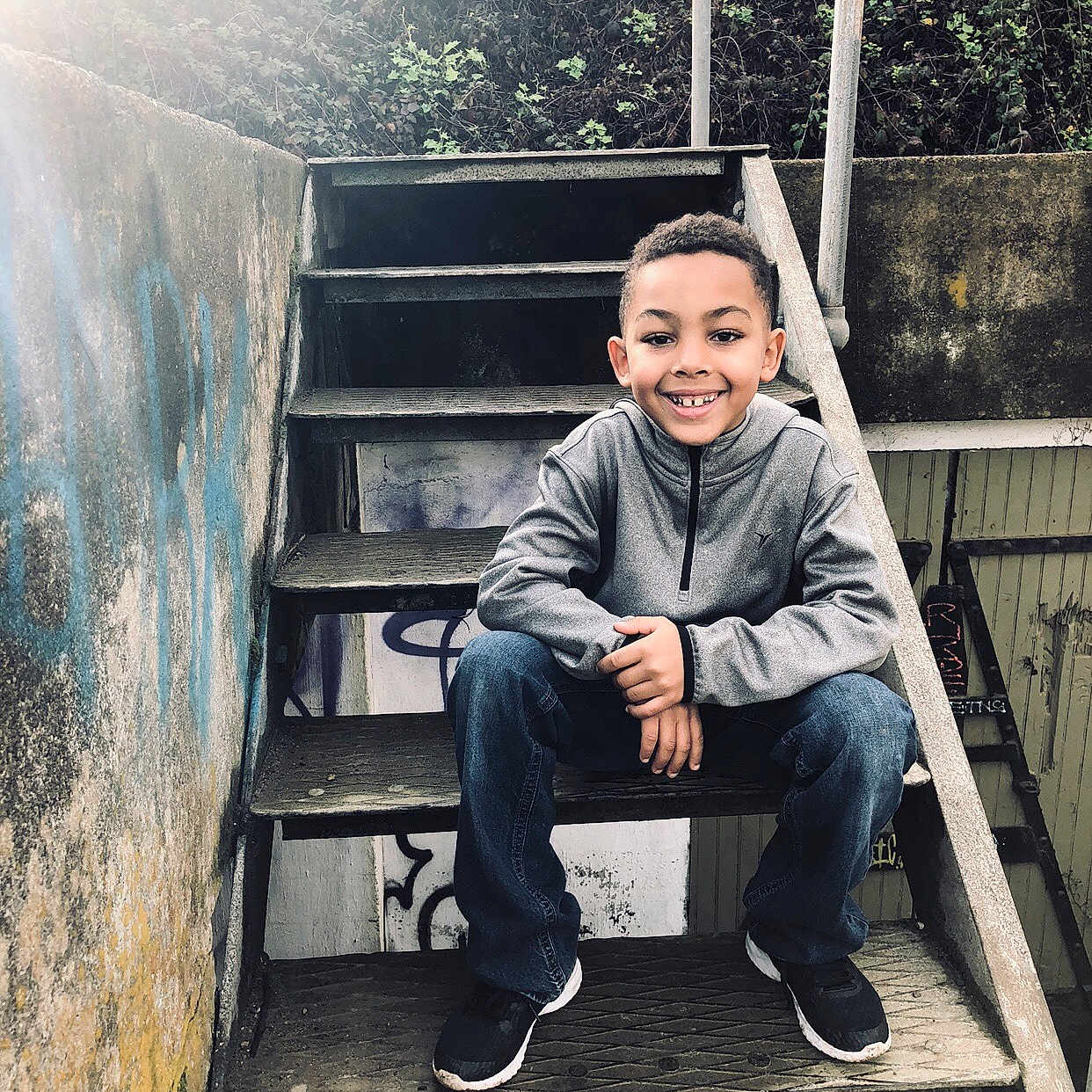 Jalen is registered to the contest to win money with this photo: child, denim, footwear, house, jeans, joy, male, person, photo_shoot, photography, shoe, sitting, smile, stairs, t_shirt