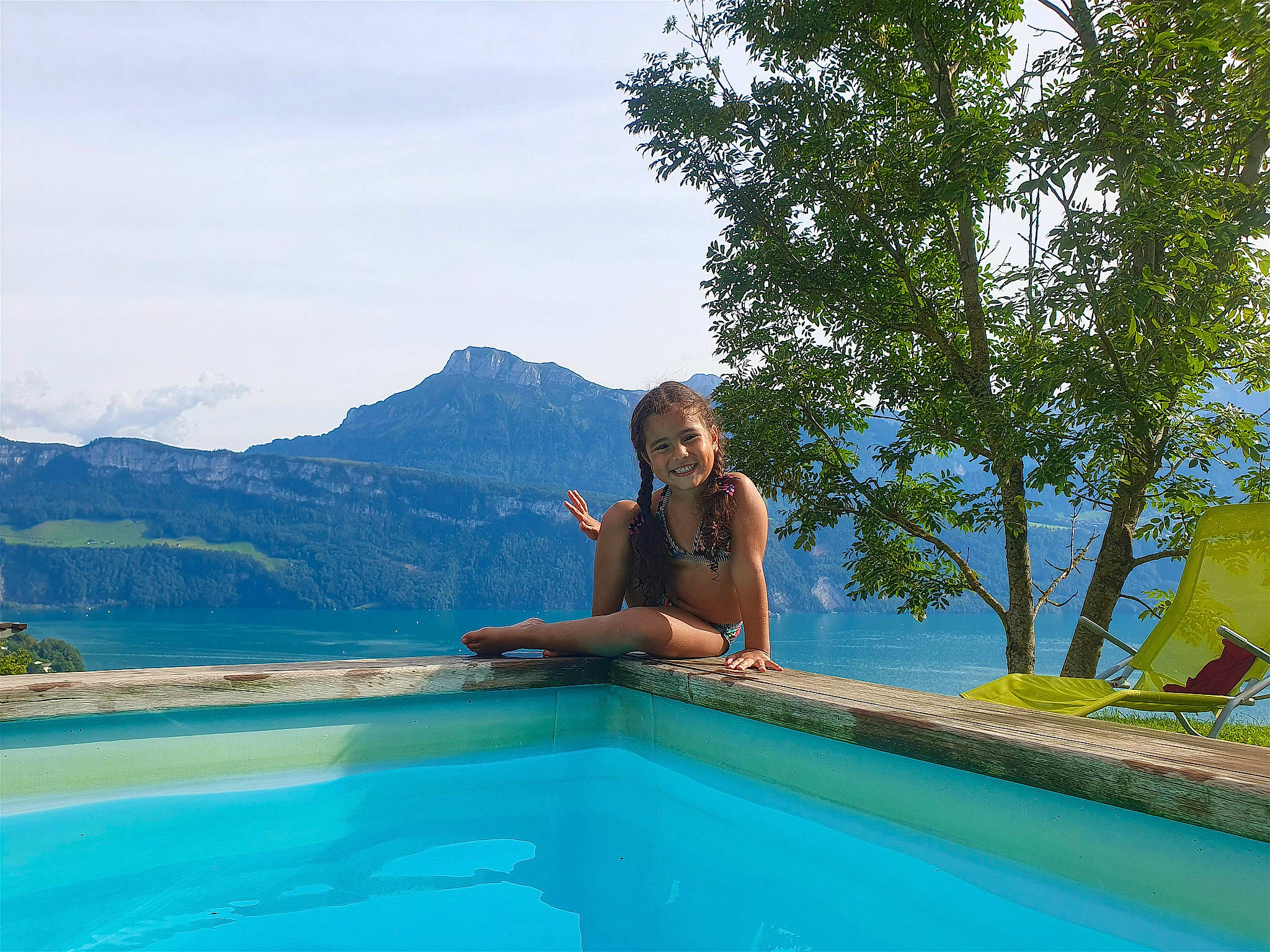 Angela a rejoint le concours — aidez-le/la à gagner de superbes lots ! azure, body_of_water, fun, grass, joy, lake, landscape, leisure, mountain, outdoor_furniture, people_in_nature, person, plant, recreation, sky, summer, swimming_pool, tourism, travel, tree