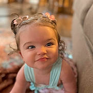 Rosalea joined the competition — help win amazing prizes! baby, child, toddler, portrait, face, eyes, blonde_hair, hair_bows, flower_hair_accessories, sleeveless_top, blue_clothing, sitting, indoors, home, couch, soft_lighting, close_up, looking_at_camera, calm_expression, photography