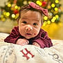 baby, infant, face, headband, bow, sweater, blanket, christmas_tree, bokeh, holiday, indoors, cute, portrait, child, young, lying_down, expression, soft_focus, warm_lighting, festive