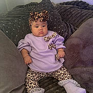 Remi is registered to the contest to win money with this photo: baby, bow, child, comfortable, couch, cozy, cute, fashion, headband, indoor, infant, leggings, leopard_print, pillows, plush, portrait, purple_clothing, resting, socks, soft_texture