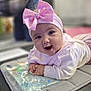 Remi joined the competition — help win amazing prizes! adorable, baby, child, closeup, cute, expression, face, hands, happy, headband, indoors, infant, lying_down, person, pink_bow, portrait, smile, soft_surface, white_sweater, young