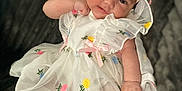 Remi is registered to the contest to win money with this photo: baby, baby_girl, bow, child, childhood, closeup, cute, dress, flower_embroidery, happy, headband, indoors, infant, lying_down, people, portrait, smiling, soft_blanket, toddler, white_clothing
