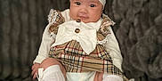 Remi joined the competition — help win amazing prizes! baby, infant, child, headband, bow, dress, plaid, white_socks, knee_high_socks, cute, smiling, portrait, sitting, blanket, soft_texture, indoors, clothing, adorable, person, young