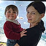 Elizabeth is registered to the contest to win money with this photo: child, toddler, girl, smile, holding, aquarium, fish, tank, water, portrait, indoor, family, happy, casual_clothing, person, young, cute, face, people, leisure