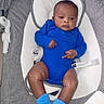 baby, infant, blue_onesie, blue_socks, baby_seat, gray_fabric, white_cushion, face, legs, arms, child, indoors, cute, portrait, baby_clothing, seat_belt, expression, human, newborn, relaxing