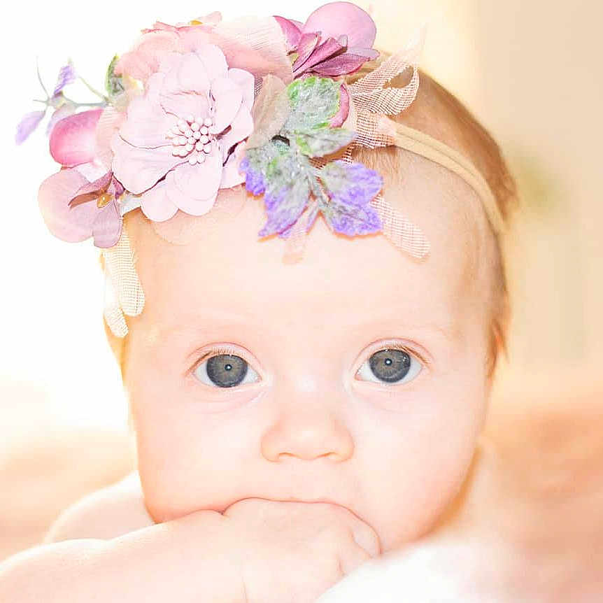 Elora is registered to the contest to win money with this photo: artificial_flower, baby, baby_toddler_clothing, cheek, child, costume_accessory, embellishment, fashion_accessory, forehead, hair_accessory, headband, headgear, headpiece, iris, petal, photography, pink, portrait_photography, skin