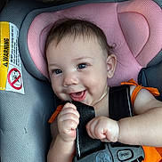 Viviyanna joined the competition — help win amazing prizes! baby, car_seat, smiling, orange_clothing, safety_harness, infant, child, seatbelt, cute, happy, portrait, indoor, warning_label, human, skin, fingers, head, eyes, mouth, hair