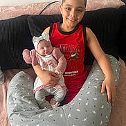 Ayoub a rejoint le concours — aidez-le/la à gagner de superbes lots ! boy, baby, child, smiling, sleeping, couch, pillow, red_jersey, headband, indoor, family, infant, sitting, holding, happy, cozy, blanket, home, portrait, person