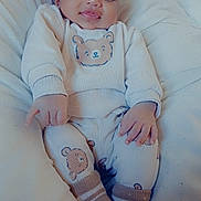 Issiaga a rejoint le concours — aidez-le/la à gagner de superbes lots ! baby, child, pajamas, bear_design, socks, blanket, soft_fabric, smile, face, hands, feet, cozy, cute, infant, comfort, resting, indoors, portrait, warm, relaxed