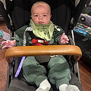 Rhett joined the competition — help win amazing prizes! baby, infant, stroller, nuna, green_clothing, bib, socks, wooden_floor, indoor, hands, face, person, seated, baby_toy, black_stroller, curious_expression, child, household, footwear, cozy