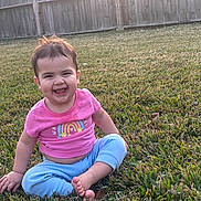 Isabella joined the competition — help win amazing prizes! child, toddler, baby, smiling, laughing, grass, backyard, wooden_fence, pink_shirt, blue_pants, barefoot, sitting, portrait, outdoors, sunlight, happy, short_hair, earrings, playtime, casual_clothing