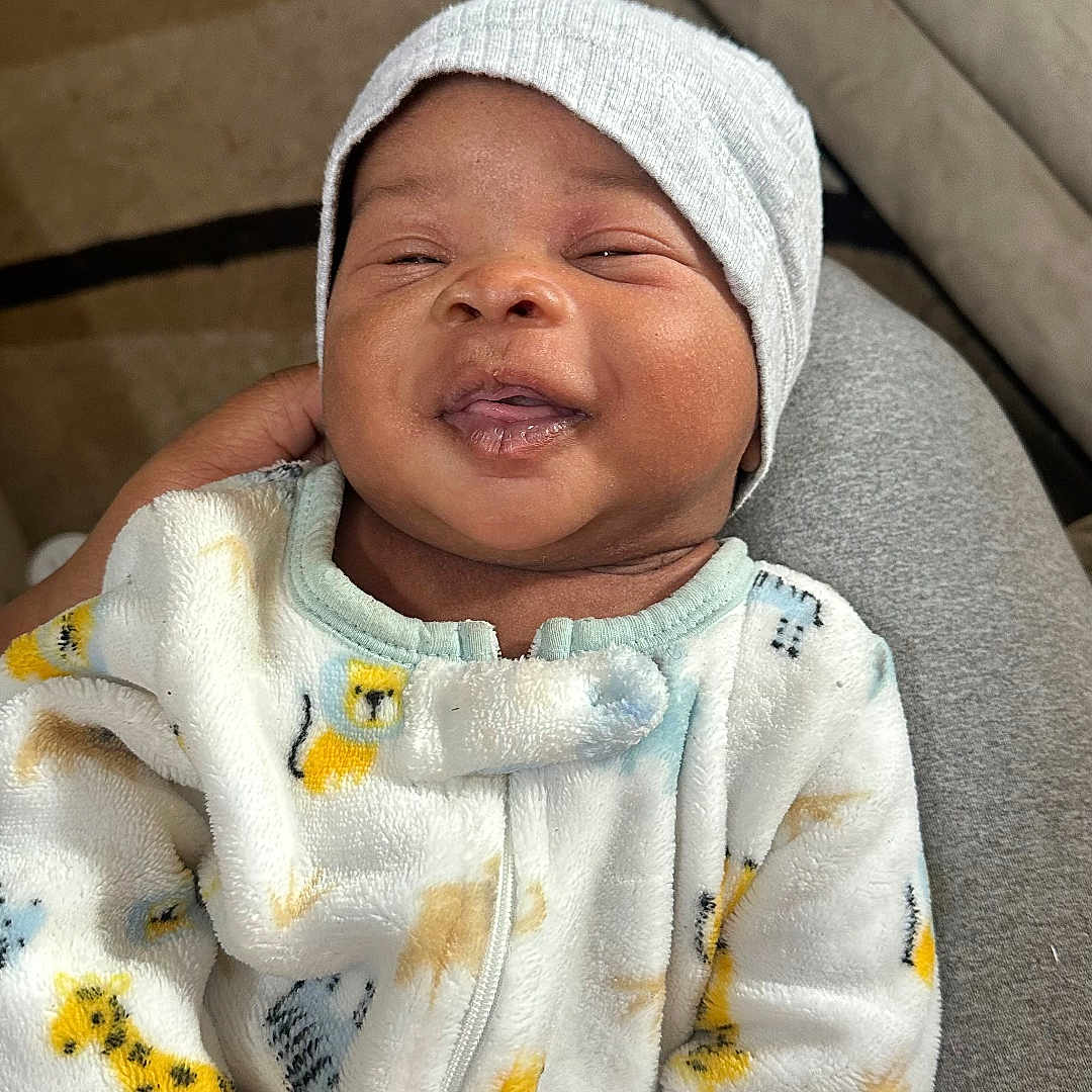 Sire joined the competition — help win amazing prizes! animal_print, baby, beanie, child, couch, cozy, cute, fabric, face, hand, happy, hat, indoor, infant, lap, onesie, person, portrait, smiling, soft