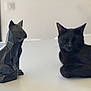animal, black_cat, cat, close_up, contrast, decor, domestic_cat, feline, geometric, indoor, minimalist, pet, relaxing, sculpture, sleeping, soft_light, statue, still_life, table, white_surface