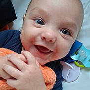 Mason joined the competition — help win amazing prizes! baby, smile, hands, blanket, pacifier, blue_clothing, infant, face, eyes, happy, cute, lying_down, child, soft_texture, closeup, skin, head, baby_toys, indoors, portrait