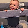baby, child, playpen, smiling, happy, indoor, toy, soft_toy, clothing, pants, black_shirt, mesh, hands, face, head, infant, cute, standing, home, baby_toy