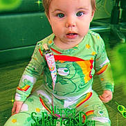 Willow is registered to the contest to win money with this photo: baby, bear, celebration, child, colorful, cute, eyes, face, floor, green_clothing, holiday, indoor, infant, pajamas, rainbow, shamrock, sitting, sparkles, st_patricks_day, text_overlay