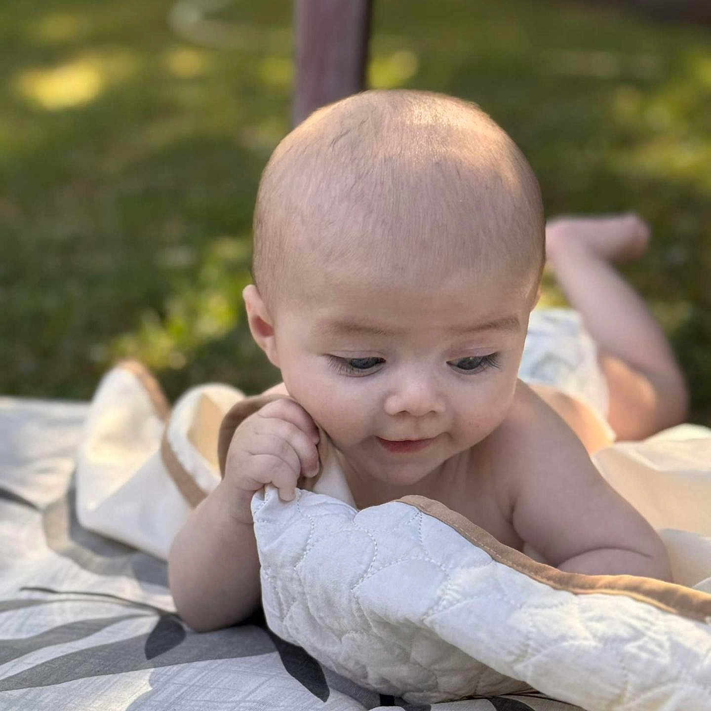 Maylone a rejoint le concours — aidez-le/la à gagner de superbes lots ! baby, blanket, child, cute, daylight, expression, face, grass, hand, head, infant, lying, nature, outdoor, person, quilt, skin, smile, soft_light, young