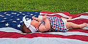 Esperanza joined the competition — help win amazing prizes! american_flag, baby, barefoot, checkered_pattern, child, dress, grass, greenery, head, headband, infant, lying_down, nature, outdoor, patriotic, peaceful, resting, side_view, skin, summer
