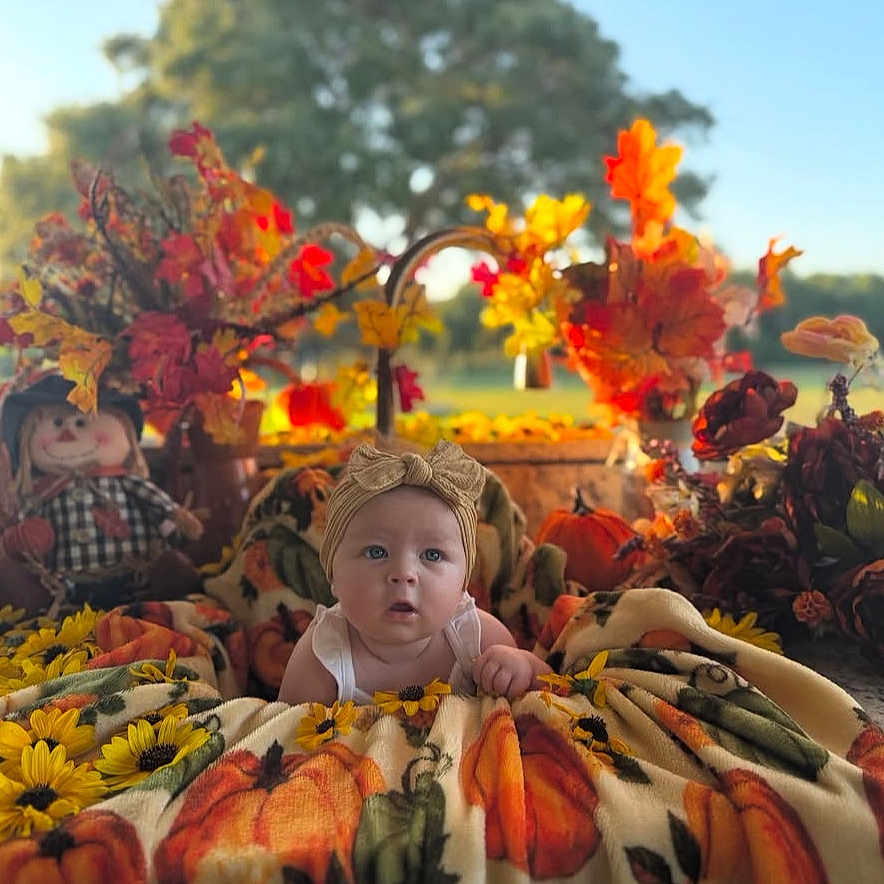 Esperanza is registered to the contest to win money with this photo: autumn, baby, blanket, cozy, cute, decoration, doll, fall, flower, green, headband, leaf, nature, orange, outdoor, portrait, pumpkin, scarecrow, seasonal, yellow