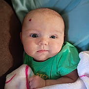 Freya joined the competition — help win amazing prizes! baby, infant, blanket, green_shirt, face, head, eyes, skin, child, indoors, portrait, cute, soft, cozy, newborn, expression, person, clothing, wrapped, resting