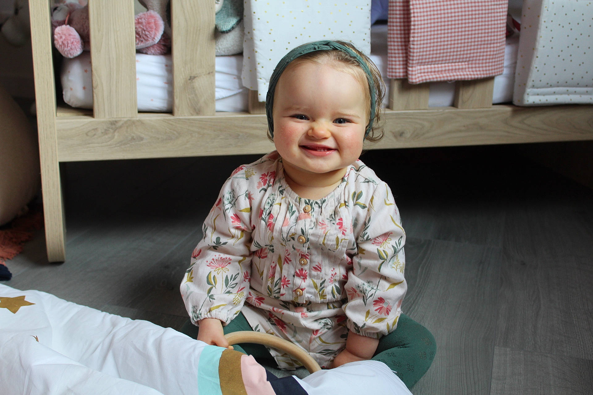 Gabriella a rejoint le concours — aidez-le/la à gagner de superbes lots ! baby, baby_toddler_clothing, cheek, child, comfort, dress, eye, flooring, fun, happy, hardwood, head, joy, person, room, sitting, skin, sleeve, smile, t_shirt
