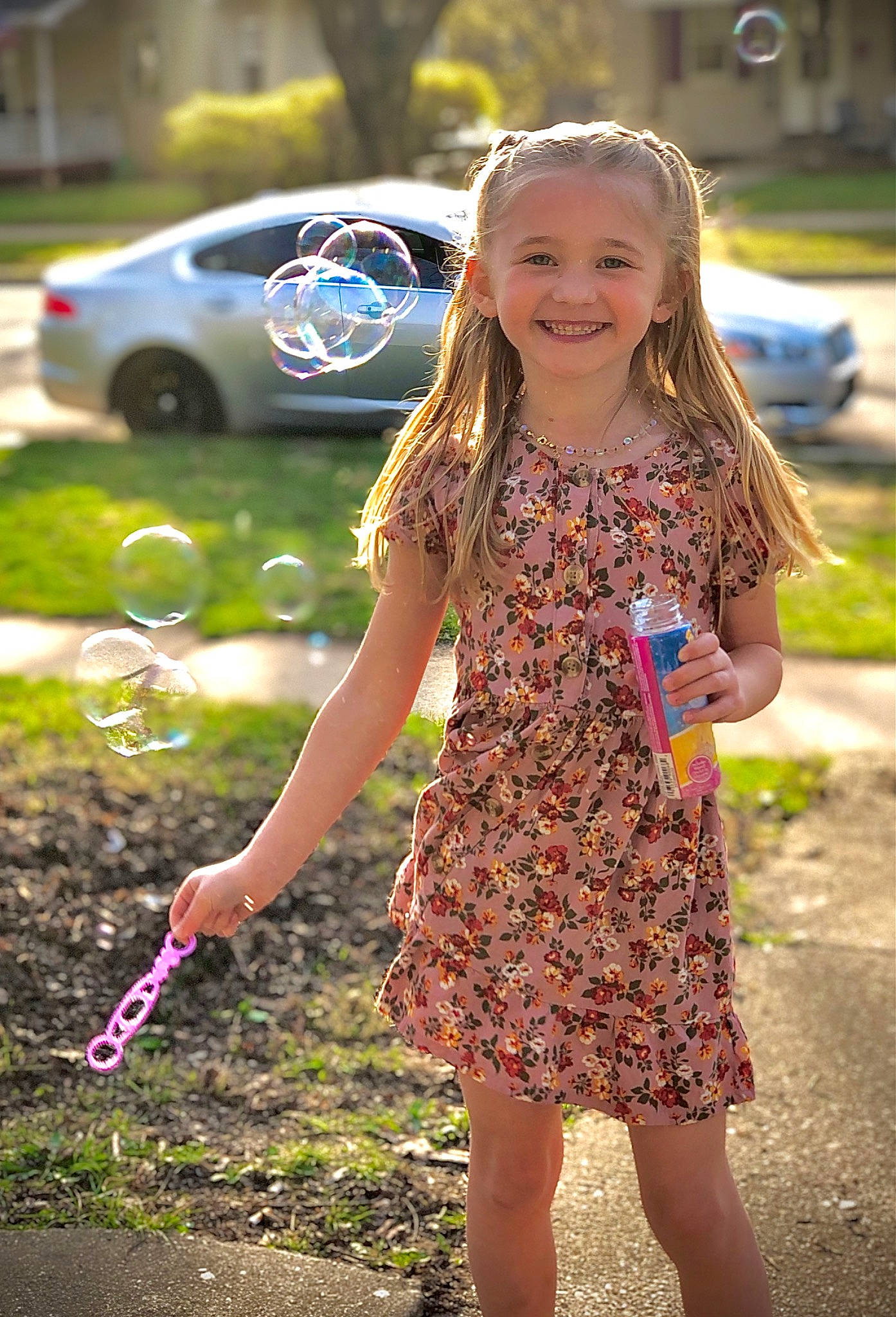 Kenleigh is registered to the contest to win money with this photo: automotive_tire, car, dress, facial_expression, finger, fun, grass, hair, hairstyle, happy, joy, one_piece_garment, people_in_nature, person, pink, plant, public_space, smile, sunlight, tire