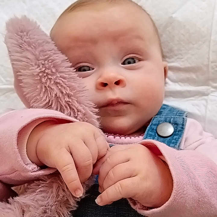 Clelya a rejoint le concours — aidez-le/la à gagner de superbes lots ! baby, child, clothing, cute, denim_overalls, eyes, face, hands, holding, indoor, infant, patches, person, pink, plush_toy, portrait, quilt, soft, stuffed_animal, young