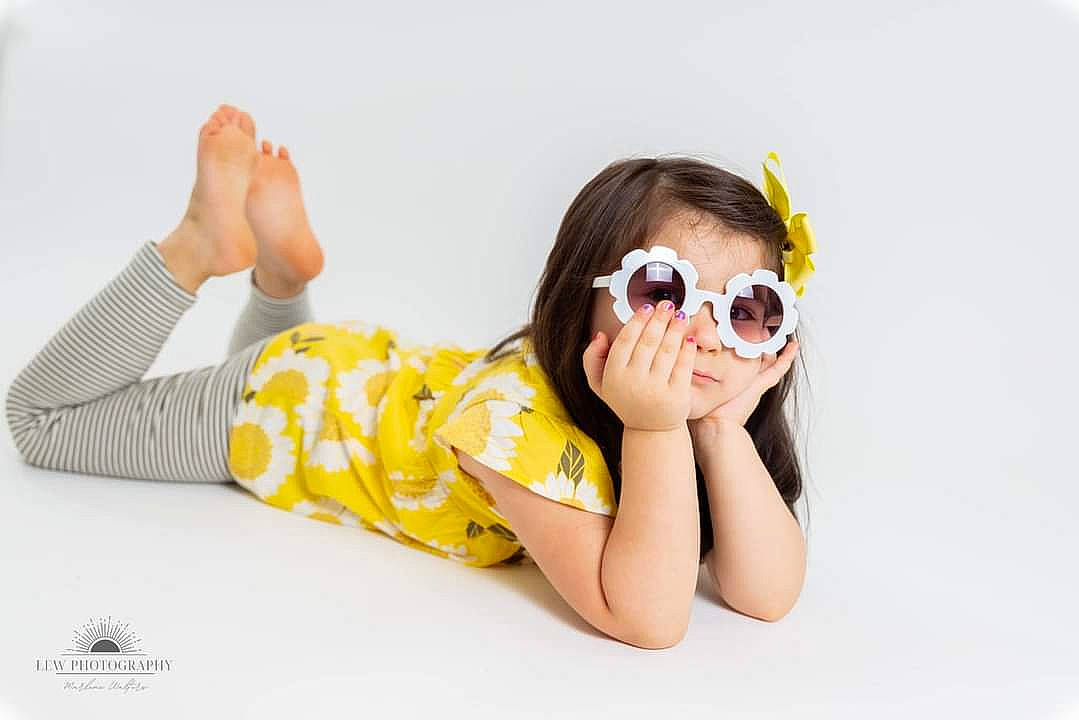 Angelica joined the competition — help win amazing prizes! arm, baby, comfort, elbow, eyewear, finger, foot, gesture, goggles, hand, happy, human_leg, knee, person, sitting, sleeve, sunglasses, t_shirt, thigh, toddler