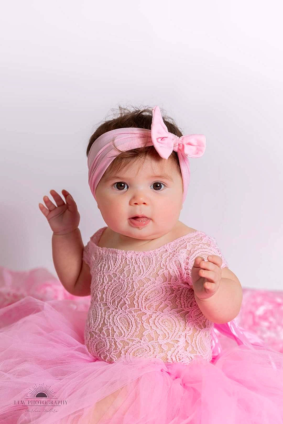 Kaliopi is registered to the contest to win money with this photo: baby, baby_toddler_clothing, child, day_dress, dress, embellishment, eyelash, flash_photography, happy, headpiece, headwear, lip, magenta, one_piece_garment, peach, person, pink, ruffle, skin, sleeve