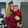 woman, baby, child, christmas_tree, holiday, indoor, family, portrait, holding, red_sweater, casual_clothing, home, decorations, tree_star, smile, person, parent, toddler, living_room, seasonal