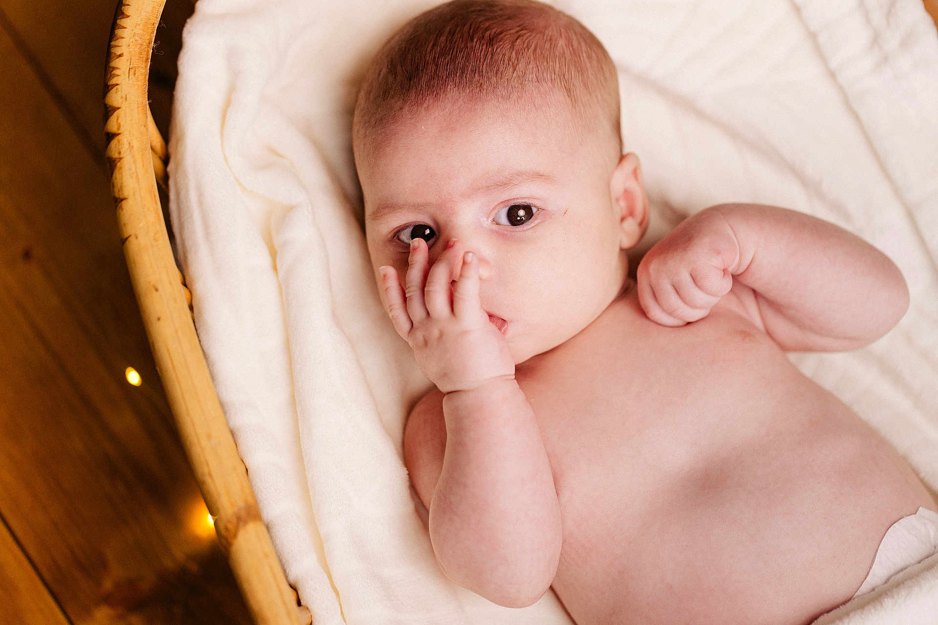 Liam a rejoint le concours — aidez-le/la à gagner de superbes lots ! baby, infant, face, hand, blanket, basket, skin, expression, naked_torso, curious, lying_down, indoors, soft_texture, wood_floor, closeup, newborn, cute, peaceful, portrait, human
