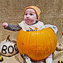 Nora is registered to the contest to win money with this photo: baby, pumpkin, halloween, orange_hat, white_pumpkin, ghost_figurine, blanket, decorations, cute, holiday, costume, toy, candle, indoor, child, festive, smiling, cozy, seasonal, celebration