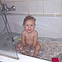 bath, bathroom, bathtub, blue_eyes, child, curly_hair, cute, glass, happy, indoor, person, playful, sitting, smiling, tiles, toddler, toy, water, wet_skin, young_child