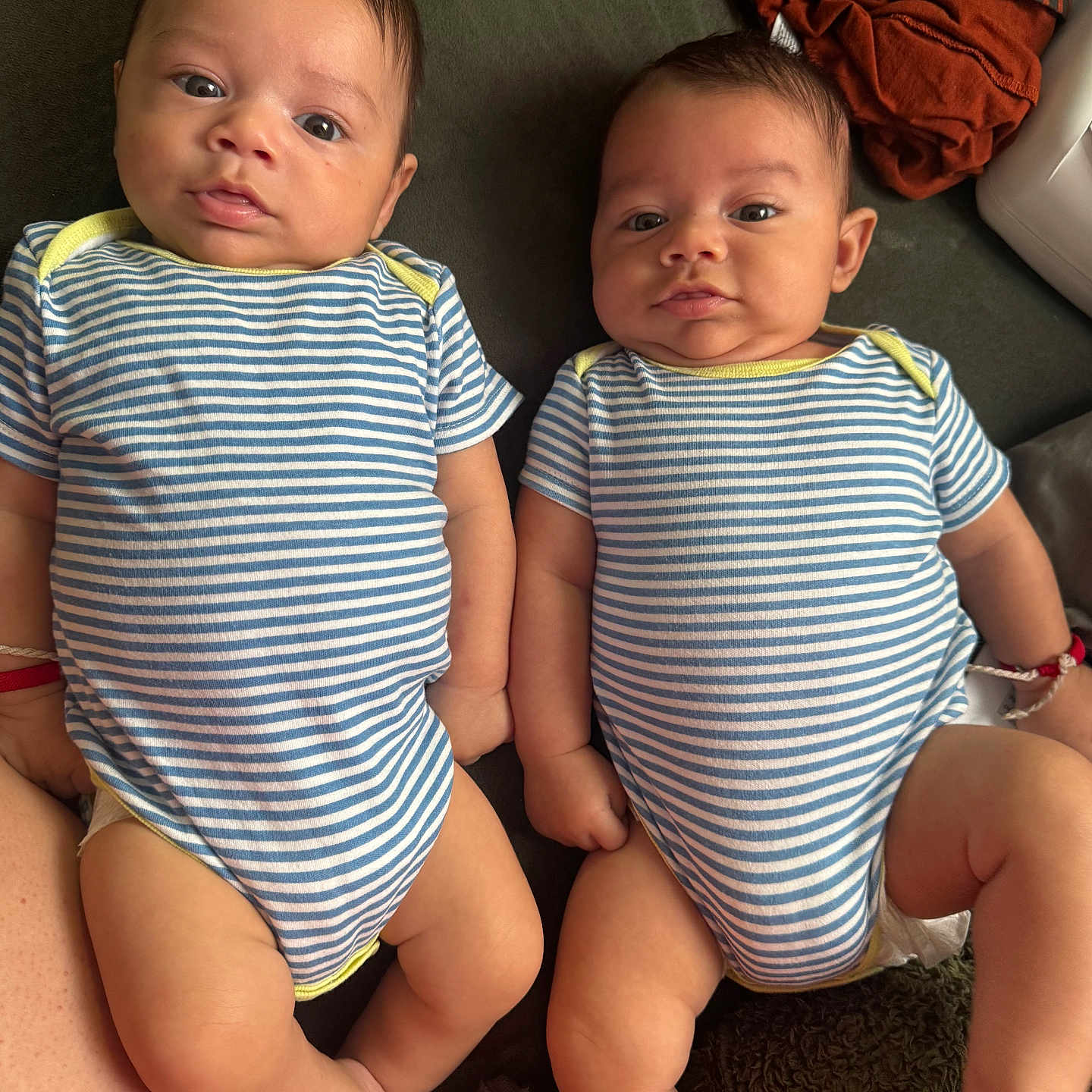 Dilan Y Lian joined the competition — help win amazing prizes! babies, blue_clothing, children, clothing, couch, eyes, fabric, faces, family_photo, indoor, infants, legs, lying_down, matching_outfits, pile_of_clothes, portrait, sitting, striped_onesies, twins, white_clothing