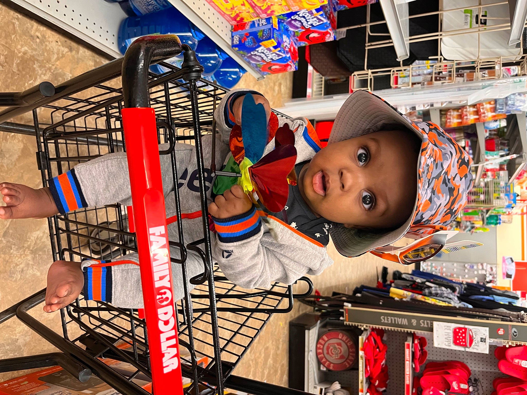 Moses is registered to the contest to win money with this photo: cap, child, city, engineering, fun, headgear, headwear, helmet, machine, people, person, personal_protective_equipment, photograph, retail, service, shopping, snapshot, surprise, t_shirt, toddler