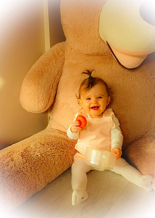 Manoa participe au concours pour gagner de l'argent avec cette photo : child, comfort, finger, foot, gesture, happy, human_leg, joy, knee, lamp, linens, person, pillow, room, sitting, skin, smile, stuffed_toy, teddy_bear, thigh