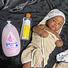 baby, towel, baby_lotion, baby_oil, infant, wrapped, cute, skin, face, head, lying_down, blanket, product_bottle, moisturizer, infant_care, baby_care, bedroom, fabric, hand, foot