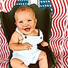 James joined the competition — help win amazing prizes! baby, child, smiling, chair, overalls, striped_clothing, happy, portrait, indoor, american_flag, background, cute, young_child, seated, face, person, infant, skin, furniture, expression