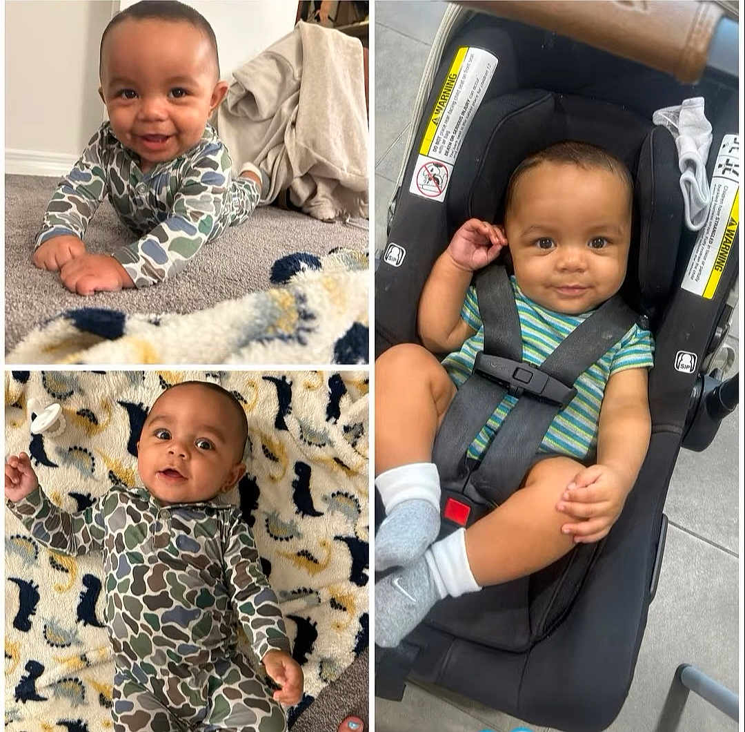 Koa is registered to the contest to win money with this photo: baby, infant, child, crawling, car_seat, blanket, dinosaur_pattern, striped_shirt, footwear, socks, smiling, curious, indoor, carpet, black_hair, seatbelt, baby_clothing, baby_pose, baby_toys, floor