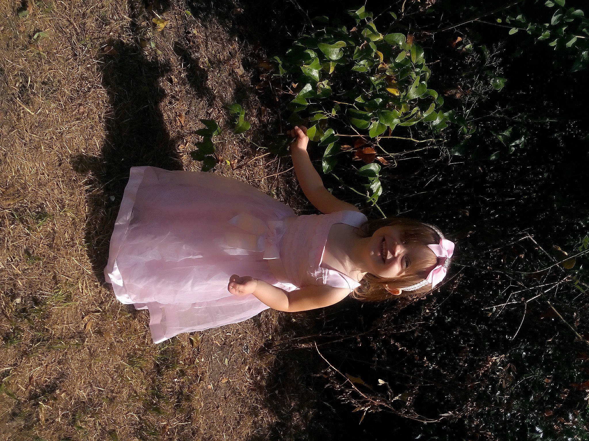 Jadex is registered to the contest to win money with this photo: bridal_accessory, dress, fawn, flash_photography, gesture, grass, happy, human_leg, joy, organism, people_in_nature, person, plant, soil, tail, thumb, toddler, tree, water, wrist