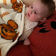 Indie is registered to the contest to win money with this photo: baby, blanket, pumpkin, orange, pillow, face, cozy, child, cute, infant, soft, warm, resting, indoor, portrait, polka_dot, sleepwear, fuzzy, comfort, toddler
