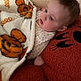 baby, blanket, pumpkin, orange, pillow, face, cozy, child, cute, infant, soft, warm, resting, indoor, portrait, polka_dot, sleepwear, fuzzy, comfort, toddler